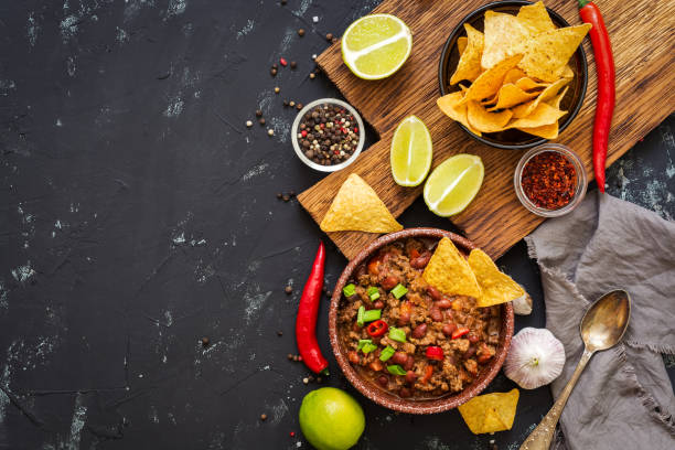 istock Chili con carne with nachos chips on rustic background 942266696