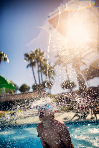 istock Little boy under tipping bucket in splash pool 942271696