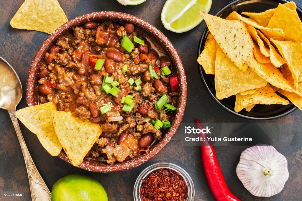 kilos with meat Mexican food dish chili con carne. The concept of Mexican cuisine. Top view, old, rusty background Chili Con Carne Stock Photo