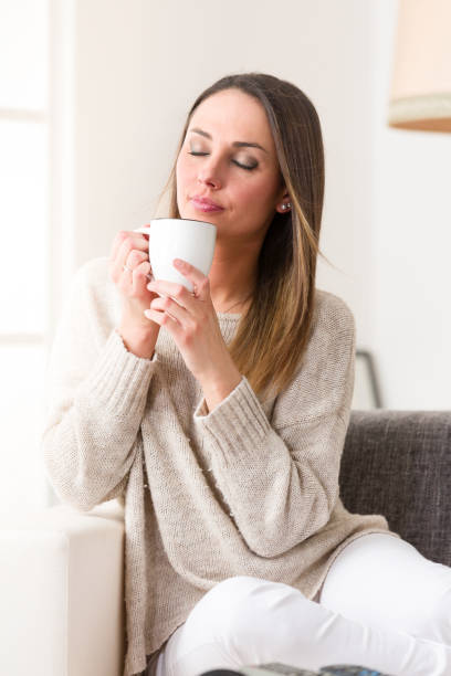 istock Young woman drinking something hot from her mug 942276006
