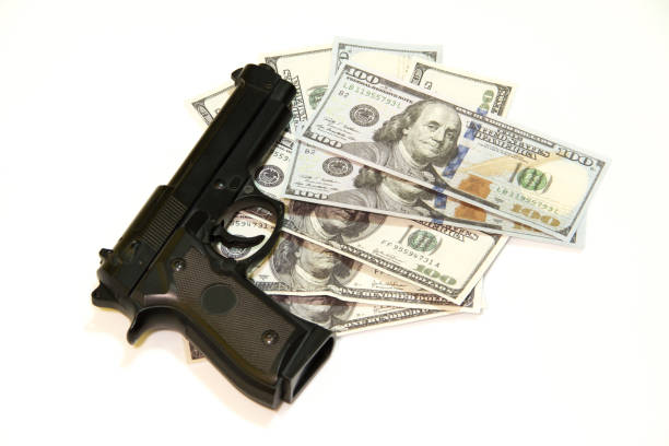 черный пистолет и сто долларов - guns and money стоковые фото и изображения