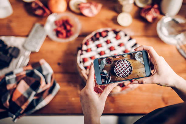 frau fotografiert ihren kuchen - essen zubereiten fotos stock-fotos und bilder