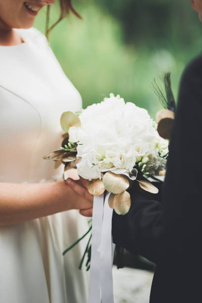 istock Bride holding big and beautiful wedding bouquet with flowers 942298148