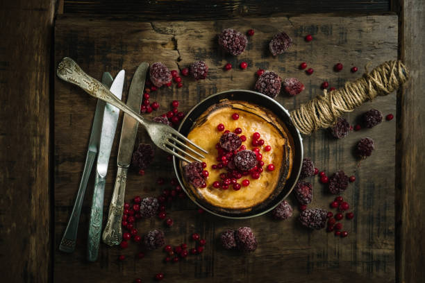 istock Stack of pancakes with berries on a frying pan on wood background.Top view. 942300786