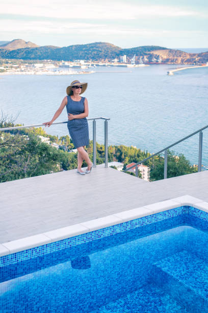 istock Woman by poolside enjoying view 942301400