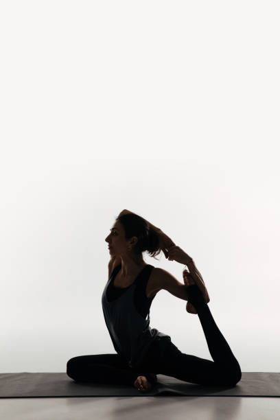 istock side view of woman practicing yoga and doing king pigeon on white 942306596