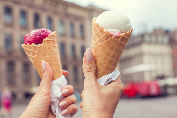 istock Two colorful tasty ice cream cones in hand 942306624