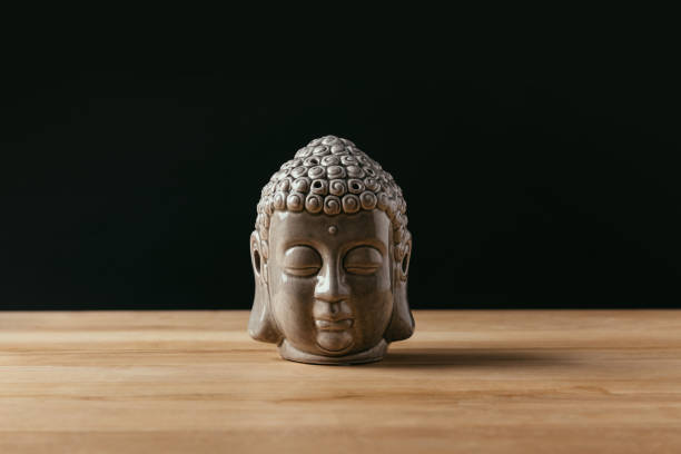 istock Sculpture of buddha head on wooden tabletop 942308786