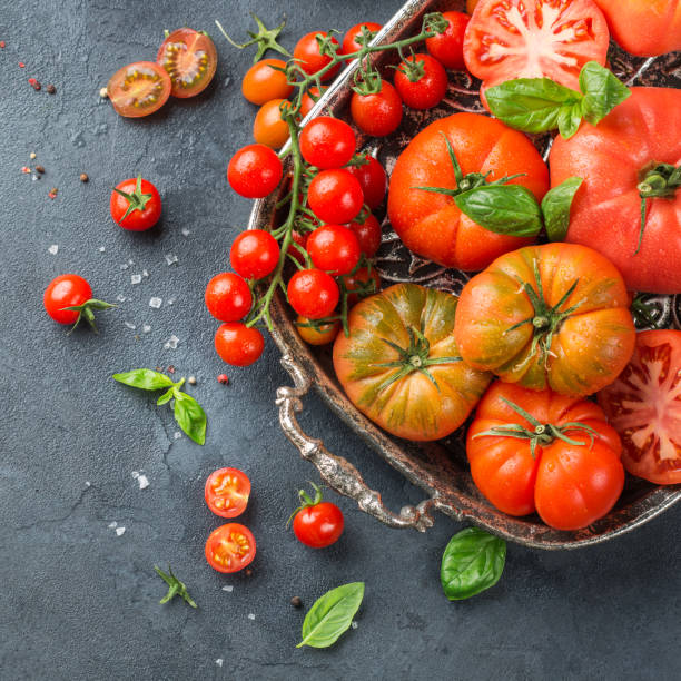 istock Assortment of ripe organic farmer red tomatoes on a table 942312370