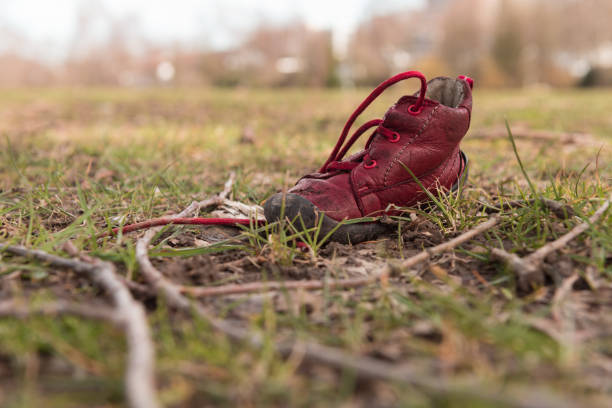 Lonely red child`s shoe in the park