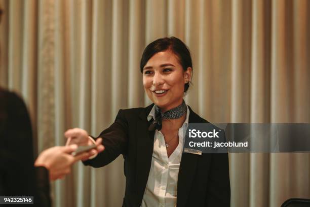 Receptionist Receiving Payment For Hotel Room From Client Stock Photo - Download Image Now