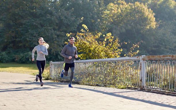 istock happy couple running outdoors 942325566