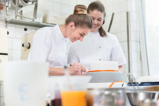 istock Women in fine backer or pastry shop baking cakes 942332122