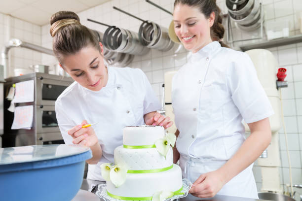 大きなケーキを飾る 2 つの菓子パン - cake women confectioner photography ストックフォトと画像