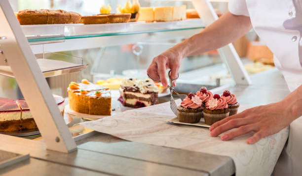 istock Baker sales woman putting pies and cakes on display 942334072