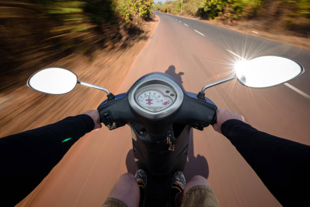 istock Rider driving scooter on an asphalt road. Motion blurred backgro 942334854