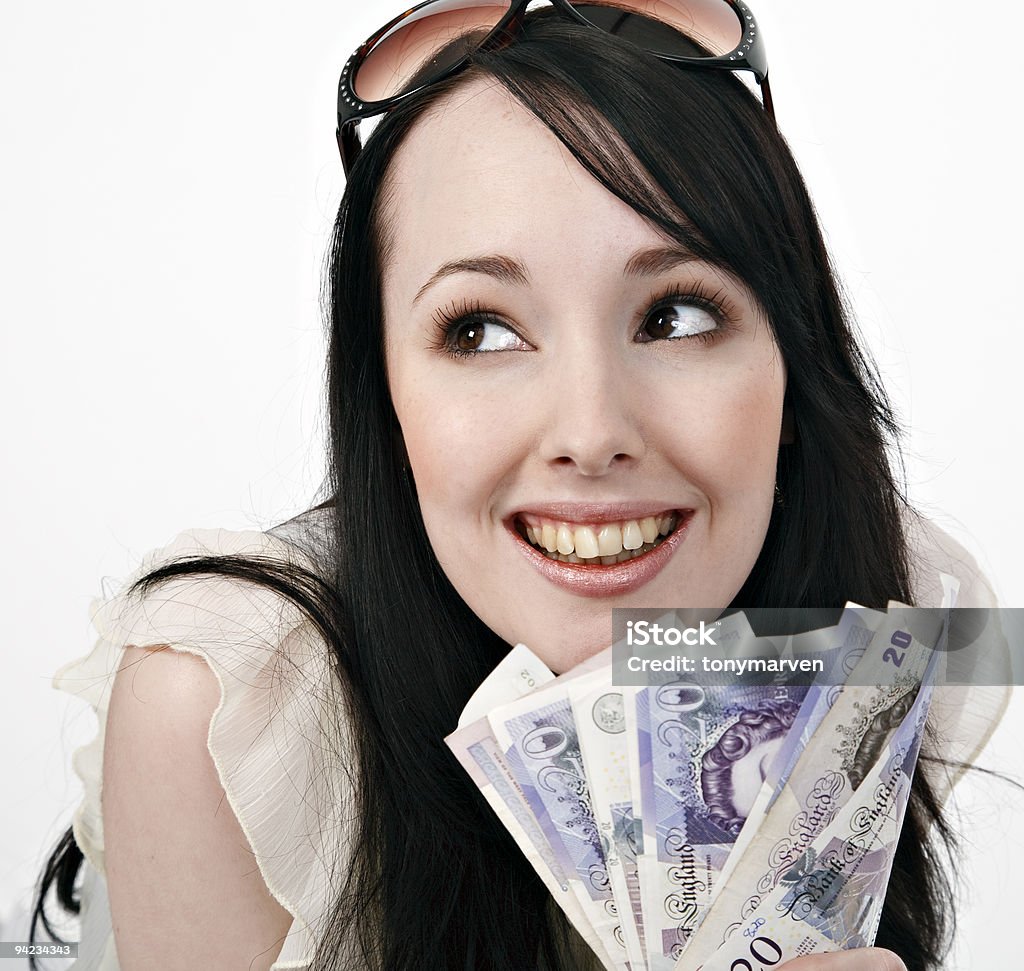 Smiling brunette young woman with handful of Canadian cash Smiling young woman with a handful of cash. British Currency Stock Photo