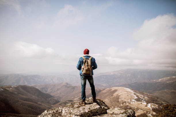 uomo in piedi sulla cima della montagna - pioniere foto e immagini stock