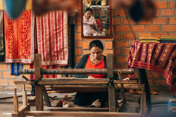 MUI NE, VIETNAM - MARCH 6, 2017: Women weavers work traditional looms for silk MUI NE, VIETNAM - MARCH 6, 2017: Women weavers work traditional looms for silk in the workshop mui ne bay photos stock pictures, royalty-free photos & images