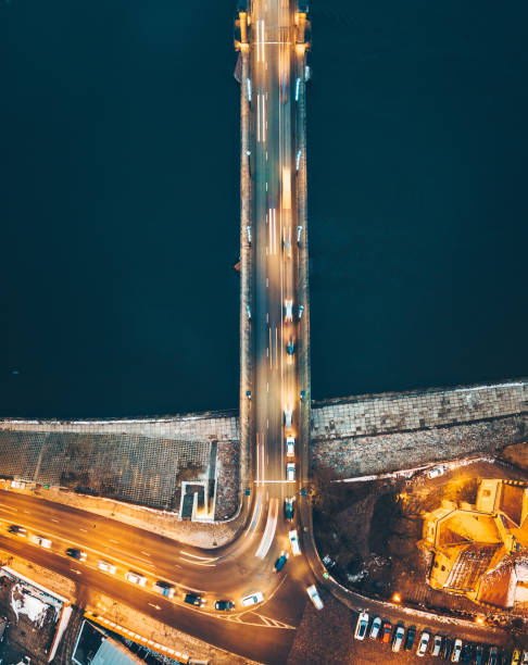 istock Aerial View Of Illuminated Bridge Over River At Night 942350032