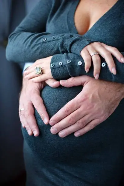 future parents gently embrace the pregnant tummy