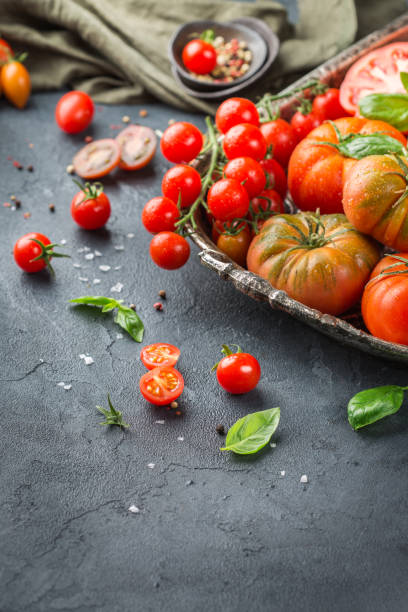 istock Assortment of ripe organic farmer red tomatoes on a table 942354036