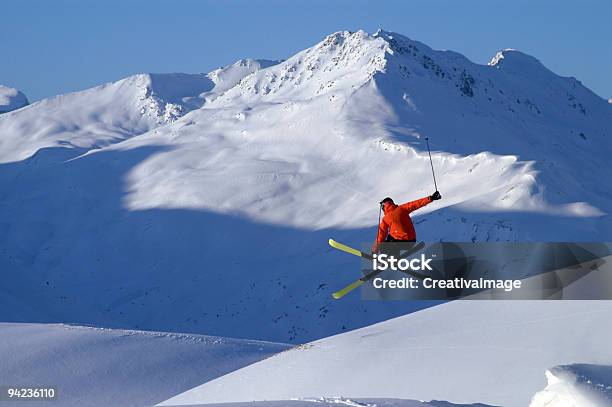 A Skier In A Red Jacket Performing A Jump Stock Photo - Download Image Now - Skiing, Snowboard, Track And Field Athlete