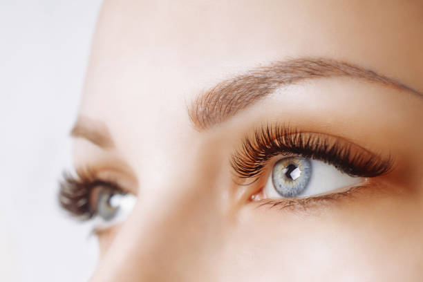 istock Eyelash Extension Procedure. Woman Eye with Long Eyelashes. Close up, selective focus 942361140