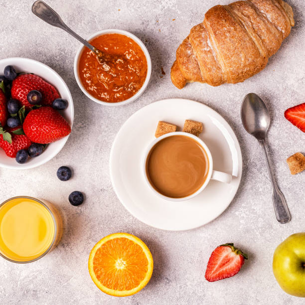 istock Continental breakfast with fresh croissants, orange juice and coffee, top view. 942364918