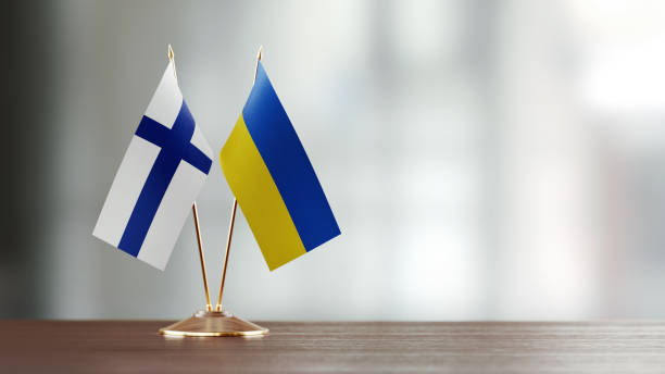 istock Finnish And Ukrainian Flag Pair On A Desk Over Defocused Background 942381746