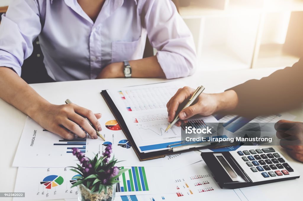 Business financial concept. busines sman and partner pointing graph paper are meeting to plan sales to meet targets set in next year. Finance Stock Photo