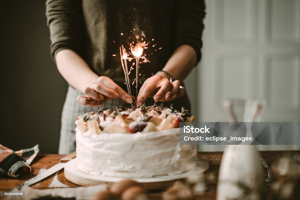 Sprinkles are all arround Woman making cake for celebration Birthday Stock Photo