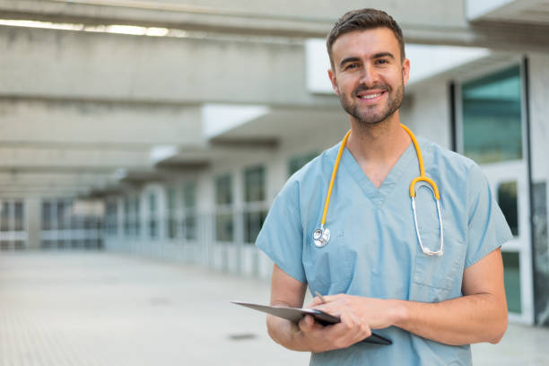 krankenpfleger mit stethoskop - digital tablet men male beauty professional occupation stock-fotos und bilder