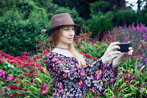 Young girl making selfie in beautiful garden