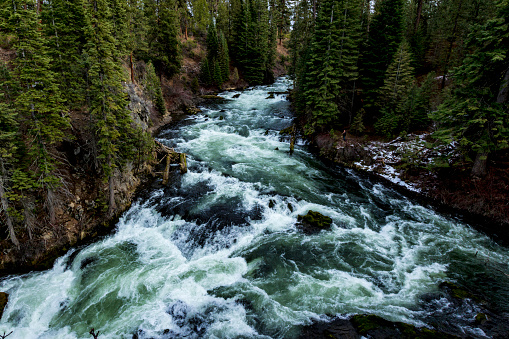 Scenic view of a round prairie spot covered with deep snow with river flowing through in Yellowstone Ecosystem in western USA, North America. Nearest cities are Denver, Colorado, Salt Lake City, Jackson, Wyoming, Gardiner, Cooke City, Bozeman and Billings, Montana.