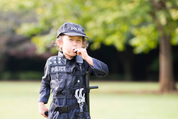 Little girl blowing whistles wearing police costumes Little girl blowing whistles wearing police costumes manhunt law enforcement stock pictures, royalty-free photos & images