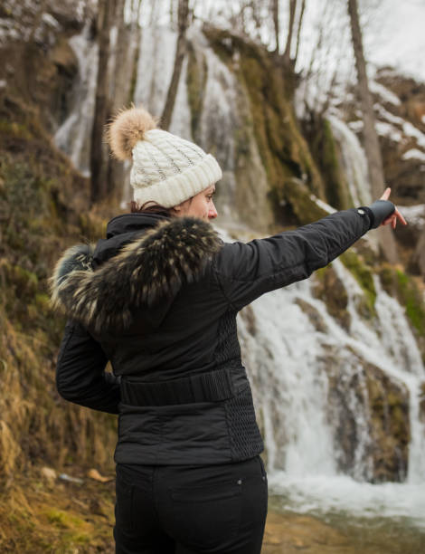 istock Female hiker looking at waterfall. 942413776