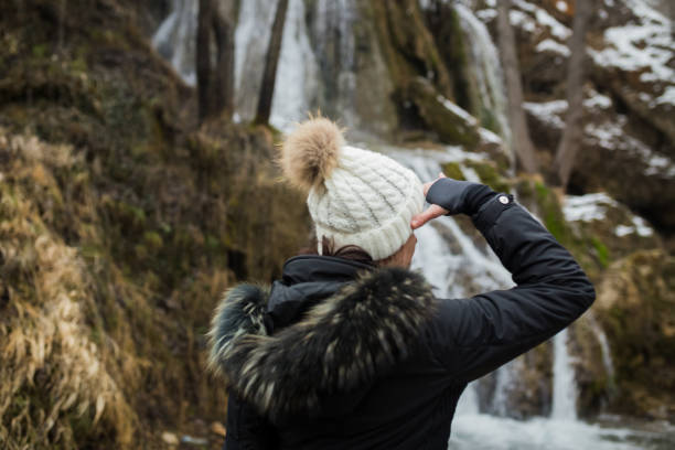 istock Female hiker looking at waterfall. 942413850