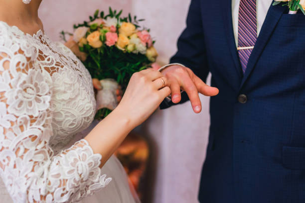 istock bride wears a gold ring on groom's finger at wedding ceremony 942416114