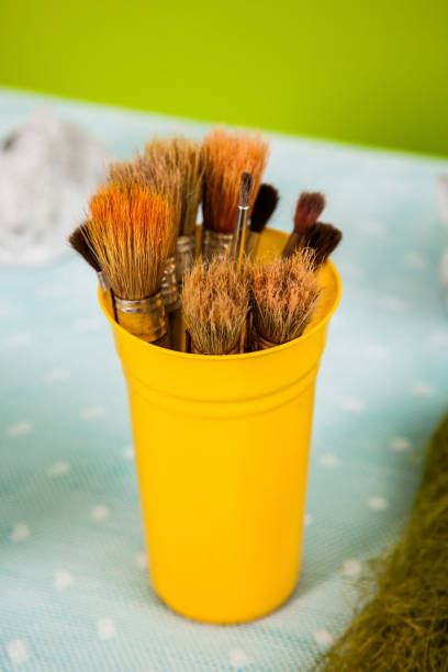 istock Brushes in a yellow metallic glass 942417812