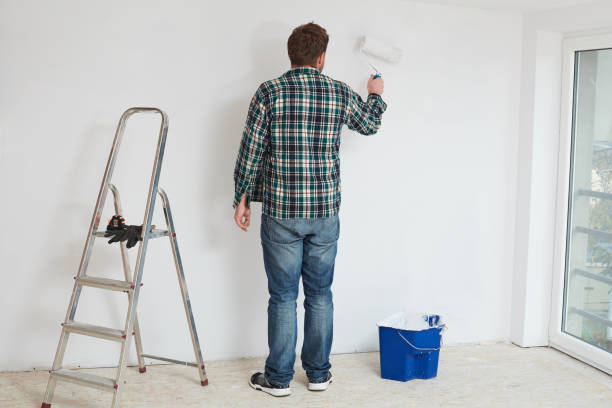 istock Young man painting a wall on white in a modern home 942420540
