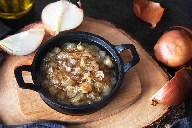 istock Fried onion in a frying pan on a wooden board 942421128