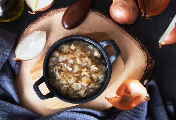 istock Fried onion in a frying pan on a wooden board 942421152