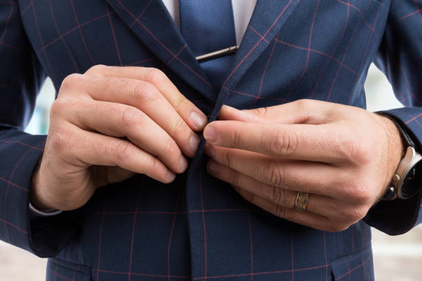 istock Man hands fastening business suit jacket button 942429320
