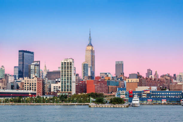 New York City Skyline at Sunset with Empire State Building, Midtown Manhattan Skyscrapers and Hudson River. New York City Skyline at Sunset with Empire State Building, Midtown Manhattan Skyscrapers, Luxury Yacht, Hudson River and Clear Sky. Magenta filter. clear sky night sunset riverbank stock pictures, royalty-free photos & images