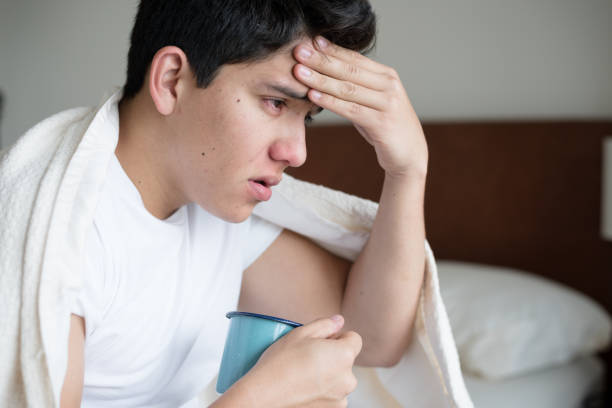 jeune homme hispanique, attraper un rhume - coughing illness men latin american and hispanic ethnicity photos et images de collection