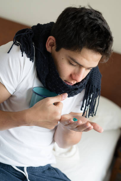 jeune homme hispanique, attraper un rhume - coughing illness men latin american and hispanic ethnicity photos et images de collection