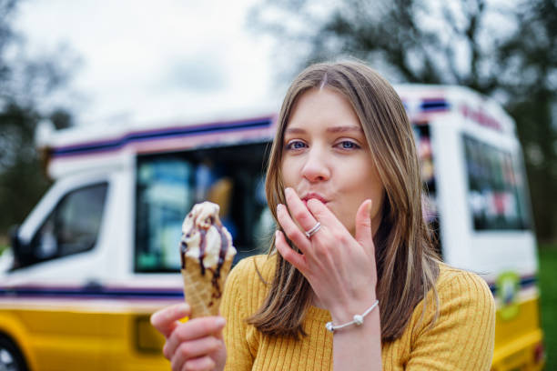 eating ice cream and sucking fingers Young Adult Girl having ice cream and sucking fingers in Coventry, UK ice cream van stock pictures, royalty-free photos & images
