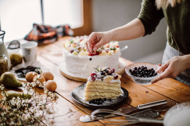 frau schnitt einen stück kuchen für den geburtstag zelebranten - plate ingredient food chocolate stock-fotos und bilder