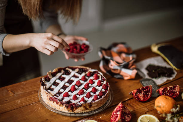 Woman Putting Raspberries To American Blackberry Pie, While It Is In  Mold